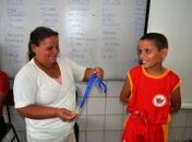 Gustavo recebendo a medalha das mãos de sua mãe, Dona Maria