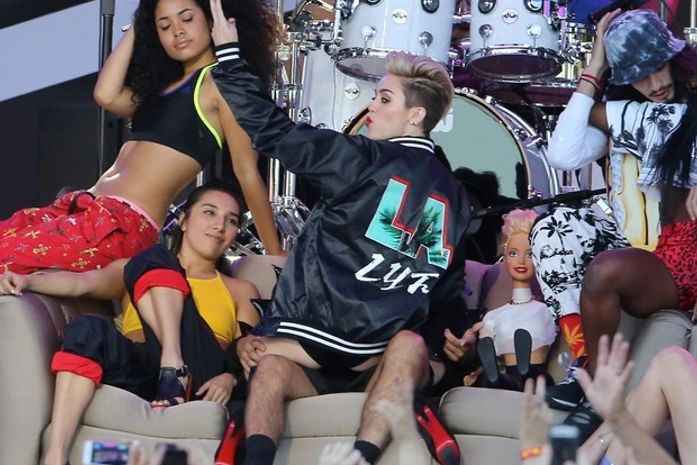 Com bota de cano altíssimo na TV, Miley Cyrus usa sofá para coreografia ousada