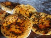 Pão árabe com manteiga temperada é uma boa pedida 