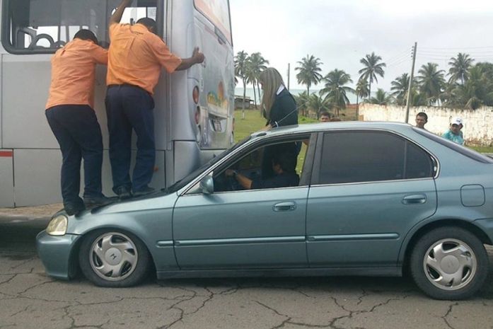 Carro vai parar embaixo de ônibus