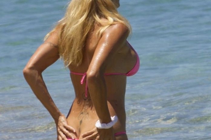Pamela Anderson usa biquíni pequeno e 'paga cofrinho' em praia