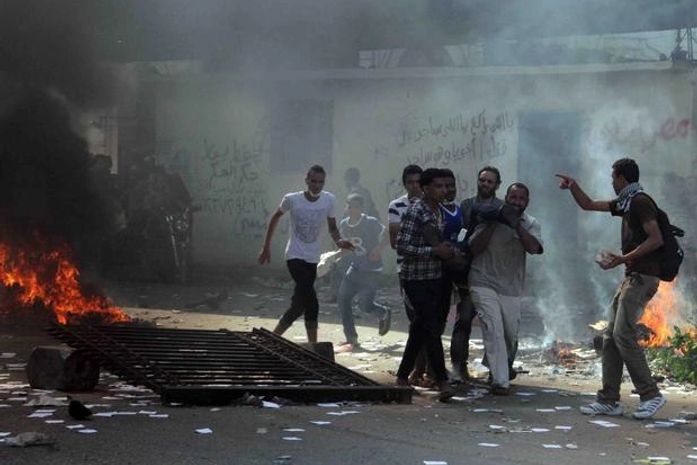 16 de agosto - Manifestantes ajudam pessoas feridas durante os confrontos na praça Ramsés