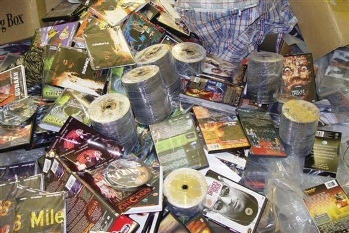 Caixa lotada de CD´s e DVD´s piratas prontos para comercialização