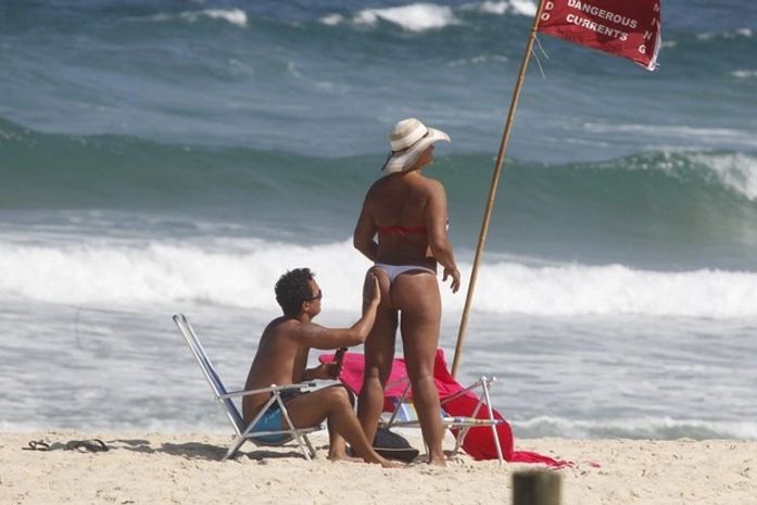 Após perder 38kg, Solange Couto vai à praia com marido e usa fio-dental