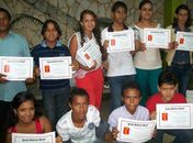 Adolescentes, jovens e adultos exibem certificados após o batismo