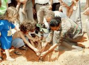 Marina plantando uma arvore com crianças