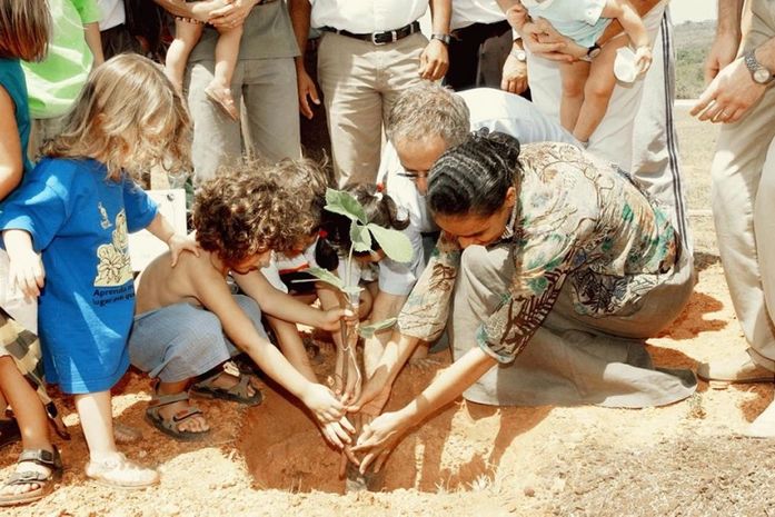 Marina plantando uma arvore com crianças