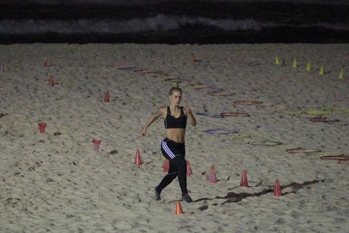 Mantendo corpo em forma! De top, Carolina Dieckmann se exercita à noite em praia do Rio