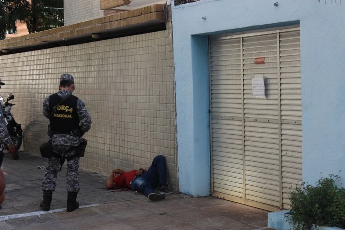 Militar da Força Nacional observa corpo do assaltante