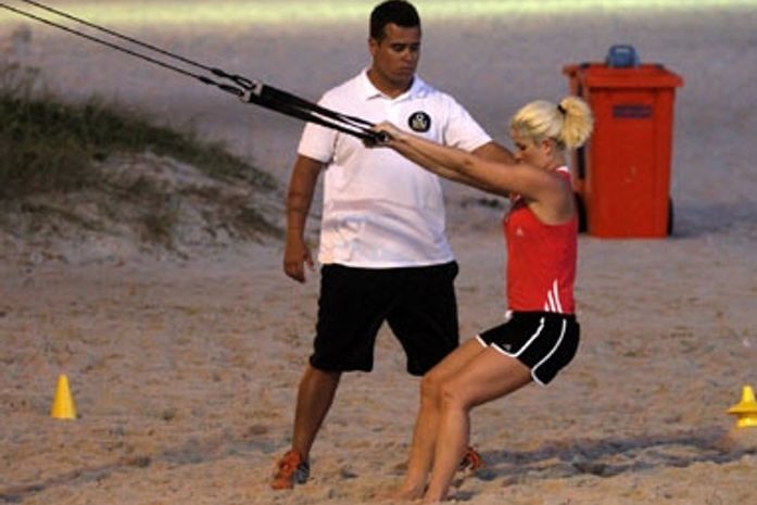 Samara Felippo malha e brinca com filhos na praia