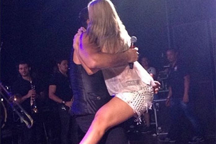 Carla Perez pula no colo de Xanddy em pleno show