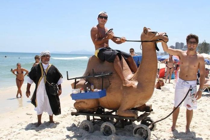 Anderson Di Rizzi e Daniel Rocha brincam com camelo falso em praia