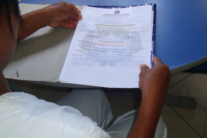 Mãe de aluna mostra os documentos que comprovam que a aluna está apta a cursar o 6º ano