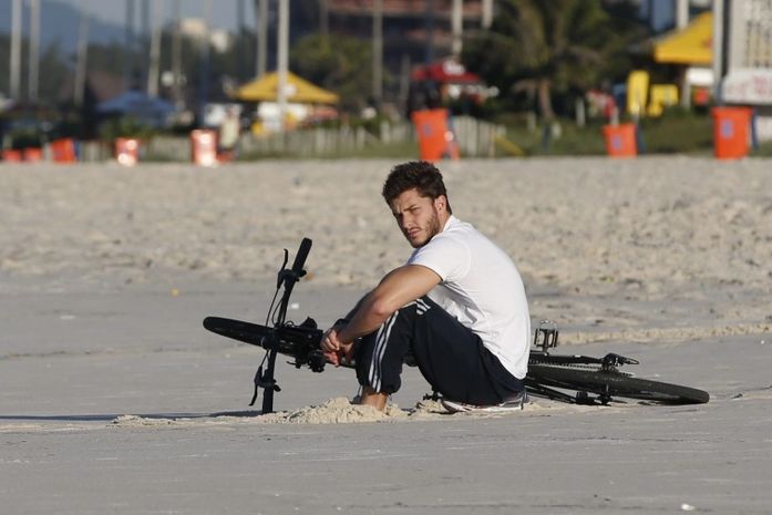 Após jornal noticiar fim de namoro, Klebber Toledo é visto pensativo na praia