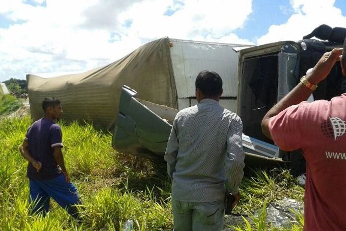 Motorista fica ferido após carreta com carga de biscoitos tombar na BR 101