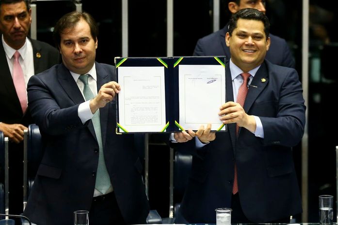 As novas regras para a aposentadoria entram em vigor imediatamente. Rodrigo Maia e Davi Alcolumbre comemoram a promulgação.