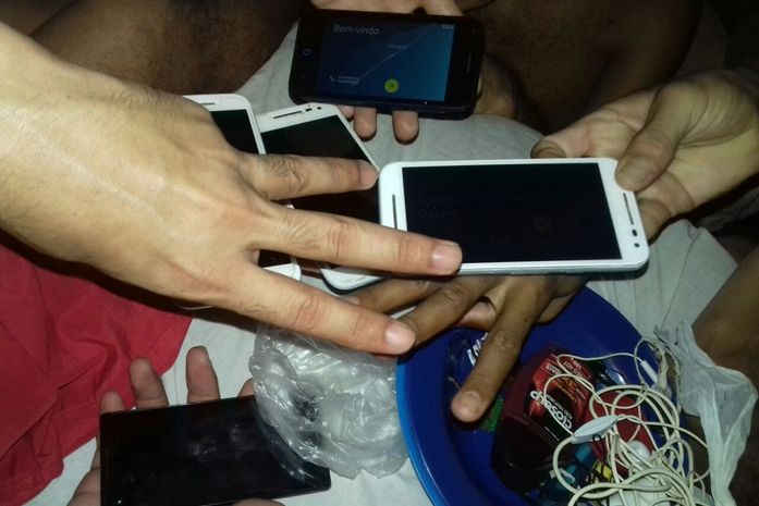 Presos mostram celulares e fazem símbolo em alusão à facção