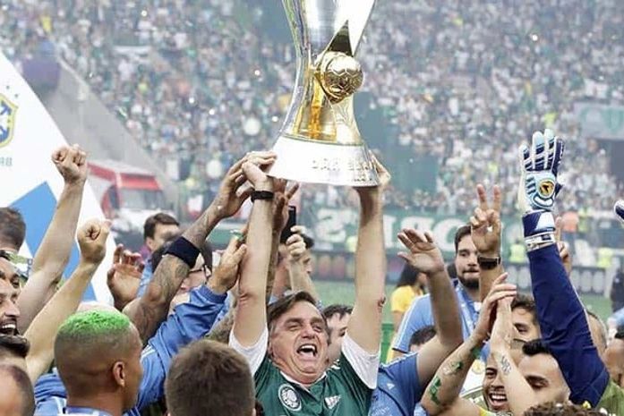 Como um recém esfaqueado e ainda muito doente consegue levantar uma taça de 18 quilos?