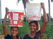 Lata d’água na cabeça,  lá vai o Carlos, 10 anos, e a irmã, sob o sol quente do Quilombo. Não tem água encanada nas torneiras.