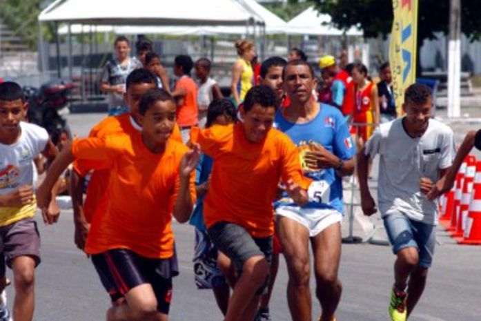 Crianças participam de competição esportiva que inclui corrida e provas de atletismo