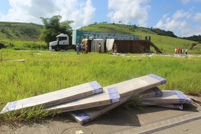 Carreta tomba, motorista fica ferido e duas pessoas são presas ao tentar furtar a carga
