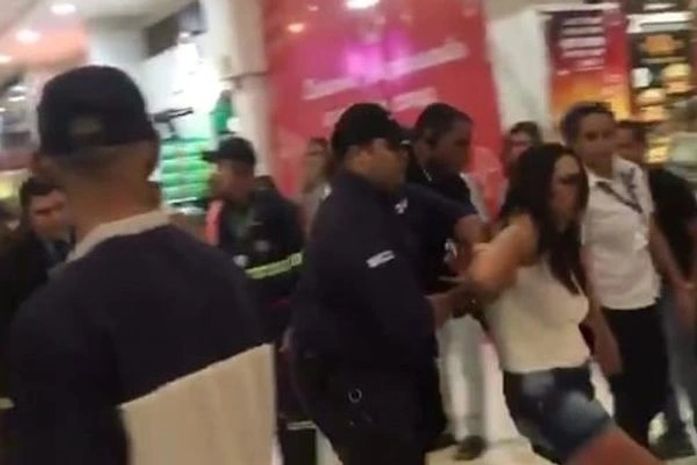 Lanna Hellen foi retirada por seguranças da praça de alimentação do shopping, enquanto protestava após ter sido impedida de usar banheiro feminino.