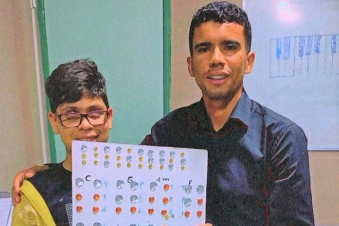 Professor da rede municipal cria instrumento e dá aulas de piano com tábua e pedras decorativas para deficientes visuais