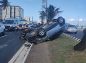 Veículo de passeio com homem e criança capota na orla da Praia da Avenida