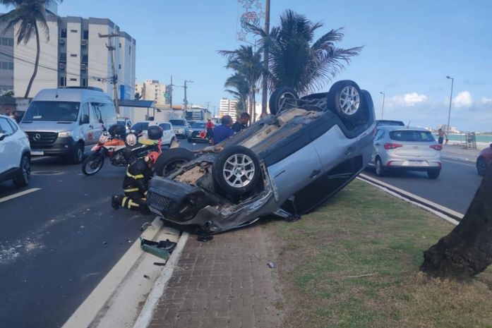 Veículo de passeio com homem e criança capota na orla da Praia da Avenida