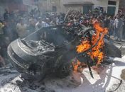 Serviços de emergência palestinos tentam apagar chamas de carro de chefe do Hamas, atingido por bombardeio israelense, em Gaza.