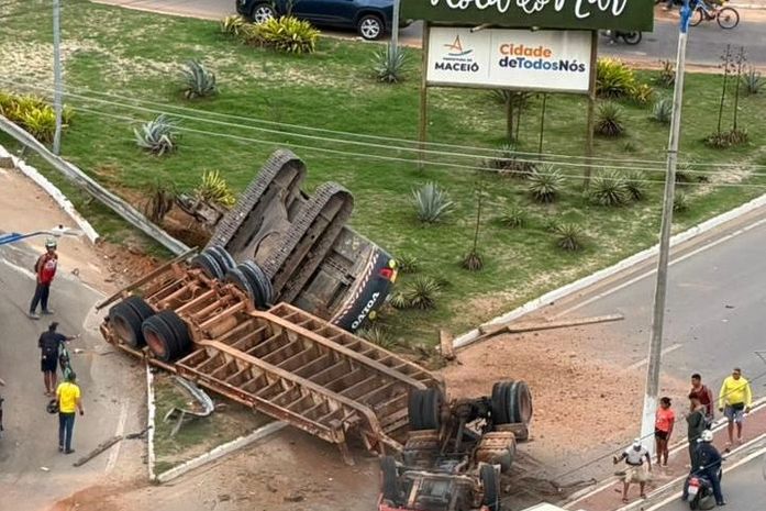 Veja o exato momento em que carreta que transportava retroescavadeira capota e deixa duas pessoas mortas na Rota do Mar