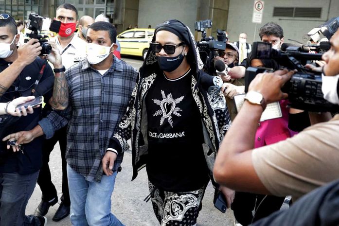 Ronaldinho e irmão desembarcam no Rio e recebem apoio de fãs