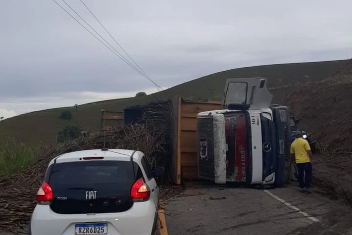 Caminhão carregado com cana-de-açúcar tomba, derruba postes e deixa vítima presa às ferragens
