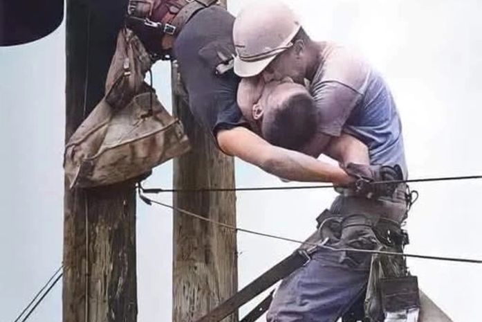 Dois homens no alto de um poste.Um lutando para sobreviver e outro se recusando a deixá-lo morrer