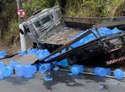 Caminhão desgovernado tomba e galões de água ficam espalhados na Leste-Oeste