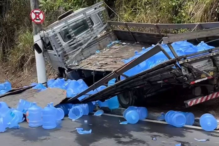 Caminhão desgovernado tomba e galões de água ficam espalhados na Leste-Oeste