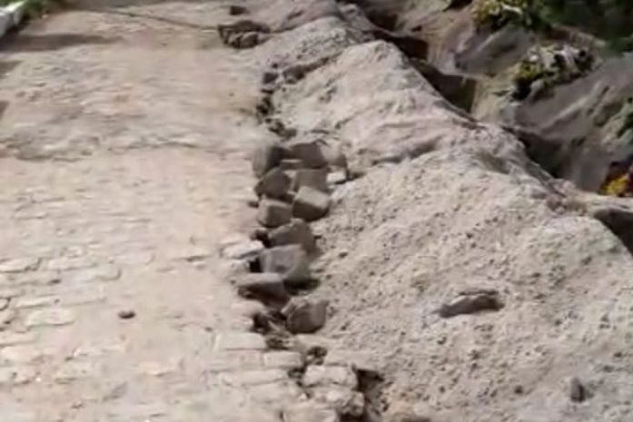 Margem da passagem de pedestres foi retirada para a abertura de novas covas no local.