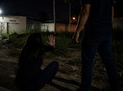 Homem agredindo mulher em terreno baldio