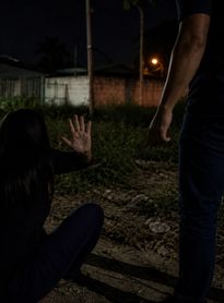 Homem agredindo mulher em terreno baldio