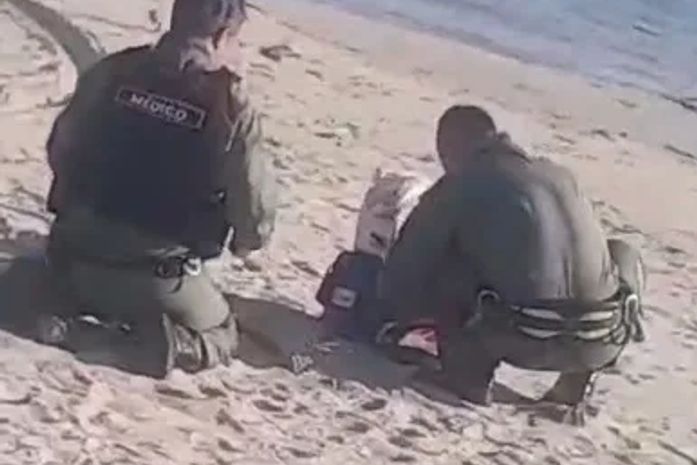 Equipes de socorristas tentam reanimar vítima após resgatá-la do mar
