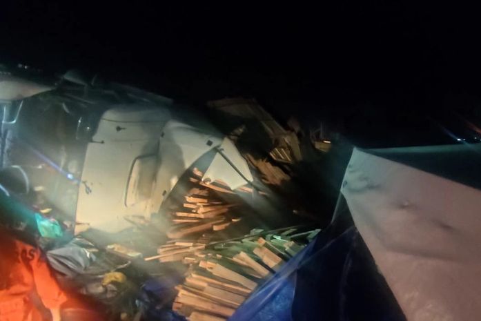 Motorista morre preso às ferragens após capotamento de carreta carregada de madeira, na BR-316