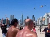 Helicóptero faz "chover" dinheiro em praia brasileira