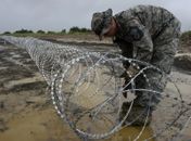 Soldado americano coloca arame farpado para delimitar área de centro de tratamento de ebola na Libéria 