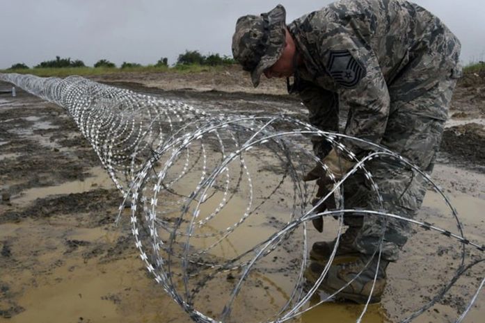 Soldado americano coloca arame farpado para delimitar área de centro de tratamento de ebola na Libéria 
