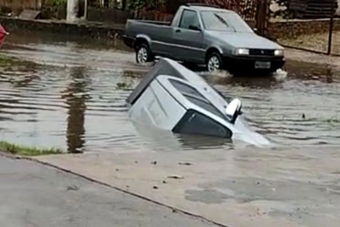 Carro afunda em buraco após fortes em Maceió