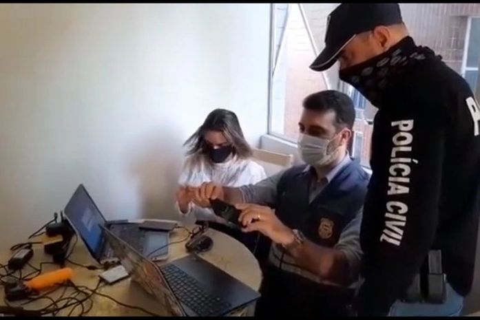 Foto: Delegada Adriana Gusmão, junto com policial civil e perito do IC, examinam material apreendido