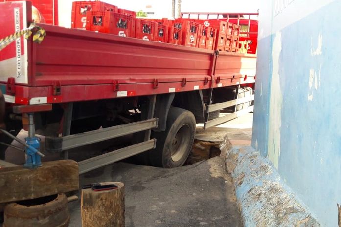 Caminhão ficou preso após asfalto ceder