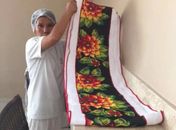Uma das doadoras, com peça feita por ela