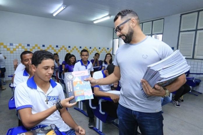 Distribuição de apostilas na Escola Miran Marroquim, no Jacintinho.