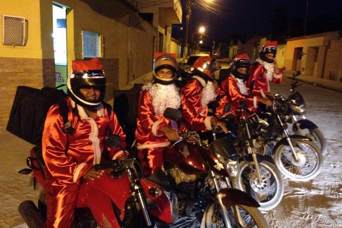 Entregadores fazem entregas vestidos de papai noel